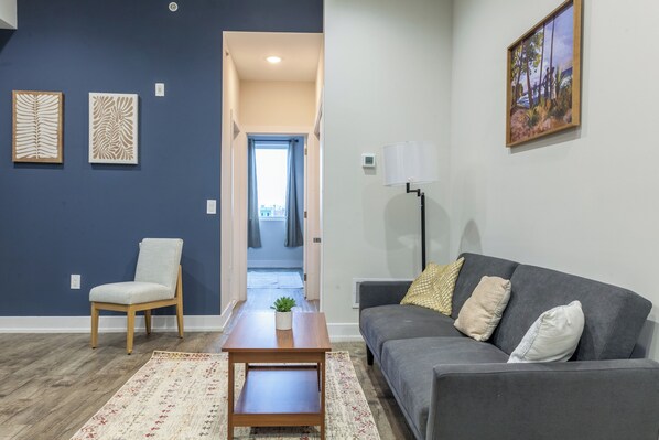 Relax in style in our chic living room adorned with modern furnishings and plenty of natural light #WelcomingSpace