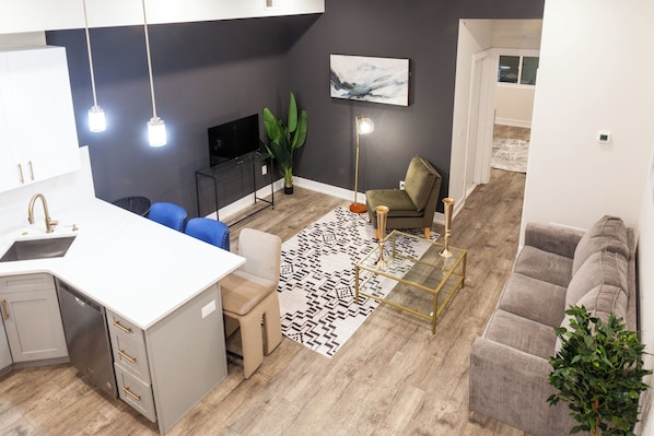 Step into our inviting living room, where a plush sectional couch beckons for relaxation after a day of exploration. The entertainment center boasts a state-of-the-art smart TV for your viewing pleasure #EleganceDefined #LuxuriousLiving 