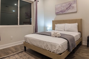 Experience ultimate comfort in our cozy bedroom featuring a luxurious queen-size bed and soft, high-quality linens #BedroomComfort #RechargeZone