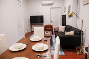 You'll find plush, comfortable seating arranged around a sleek coffee table, ideal for unwinding after a day of exploring. The accent wall adds a pop of color, complementing the neutral tones of the furnishings. A tasteful rug ties the room together, providing a touch of luxury underfoot.