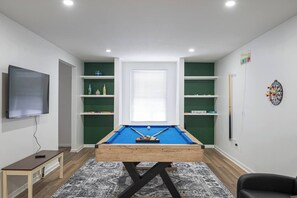 Game room with Pool table, darts board, board games and TV. 