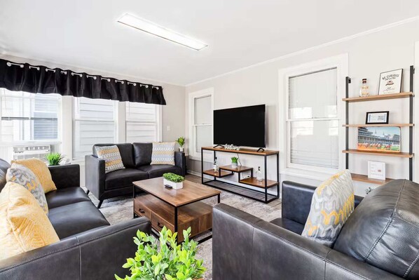 Living Room - Unit 1 - Unwind & Watch – Comfortable seating with a Smart TV for entertainment.