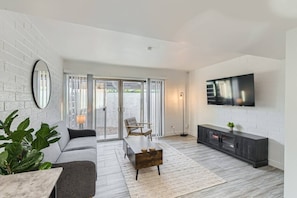 Modern open concept living room with 55in TV and couch that folds into a futon.