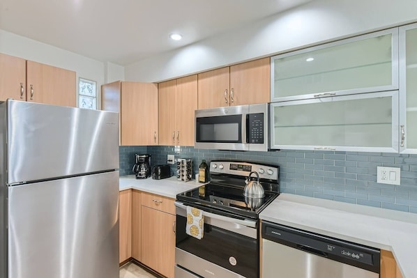 Fully stocked kitchen with olive oil, spices, tea kettle, coffee, coffee pot and much more.