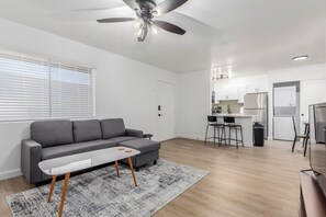 Relax in style with a comfy sofa, smart TV, and big windows that fill the room with natural light — perfect for movie nights or lazy mornings.