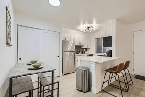 The space is open concept with 4 stools around the pub style table and 2 additional bar style chairs to pull up to the kitchen counter. 