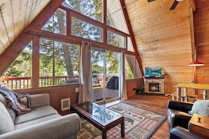 Bright, airy, and inviting—this living room features stunning windows, a fireplace, and Smart TV.