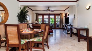 Spacious condo with dining table, living area and private balcony overlooking the resort