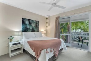 Recharge in the primary suite with a queen bed, a walk-in robe for effortless unpacking, and direct access to the wraparound balcony where the morning breeze drifts in through the palms.