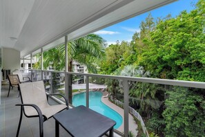 Unwind in the sitting nook on the wraparound balcony, overlooking the lagoon pool and treetops—an ideal perch for morning coffee or quiet moments.