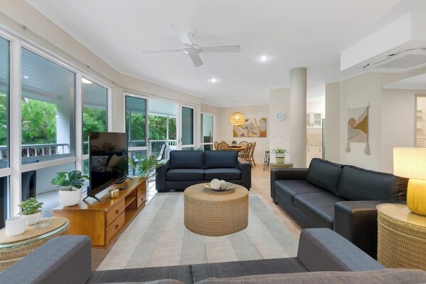 Stretch out on soft lounges and binge your favourite series in the art-filled living room, where leafy treetop views and a ceiling fan create a peaceful escape from the tropical heat.