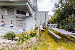 this yard space is shared and has a barbecue pit.