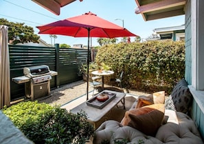 Cozy Patio Setup Featuring BBQ Grill, Comfy Seating, and Umbrella