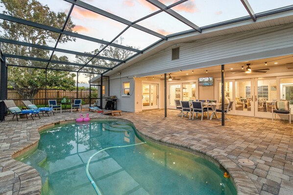 The pool and patio with Lanai dining - all screened in for comfort.  Chaise lounges, seating and grill can be seen in the distance.
