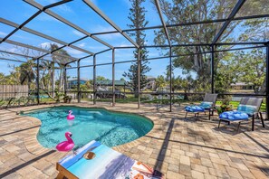 Patio with chaise lounges and corn hole game.