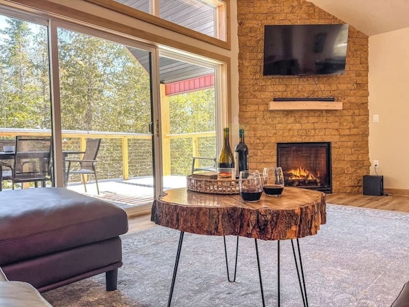 Living room features large sliding glass doors that lead to a deck in the tree tops. Turn the gas fire place on for a cozy winter day in.