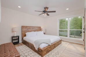 King sized bedroom with ceiling fan. 