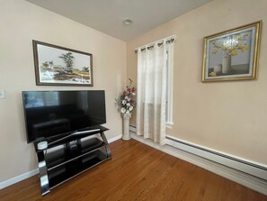 Quaint Living Room Area featuring Smart TV - Couch folds open to be used as a sleeper