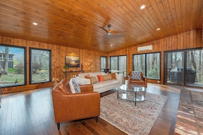 Open-concept living room with gas log fireplace and dining area for 8