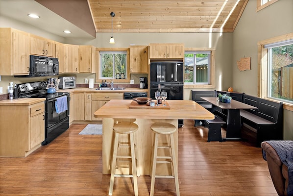 Fully stocked kitchen with island and breakfast nook opening up to the living room.