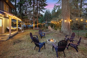 Enjoy a serene backyard with fire pit, BBQ, love seat rocking chair and covered hot tub.