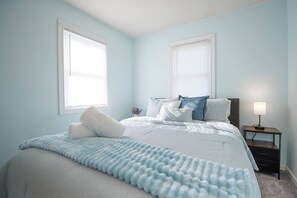 Dreamy Bedroom: Relax in serene blue tones with a plush bed and natural light streaming in!