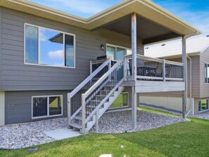 Covered deck that is shaded with grill and dining - steps down to large yard