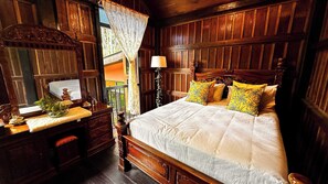 A bedroom with a queen sized bed & plush pillows.