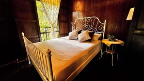A bedroom with a queen sized bed & plush pillows.