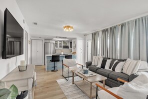 Open concept living area with stylish furnishings TV and pull out couch