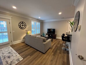 View of the living space from the bedroom.  Door leading to covered patio