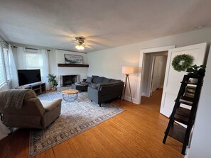 View of the living room with recliner and sectional couch.  We have a smart TV with streaming capabilities.