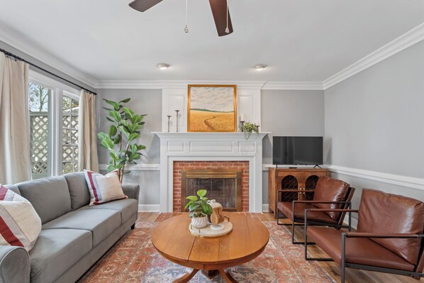 View of the living room with tons of natural light and seating spaces.