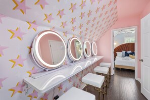 Ring lights, pink walls, glam mirrors—get ready in total star-ceiling style!

