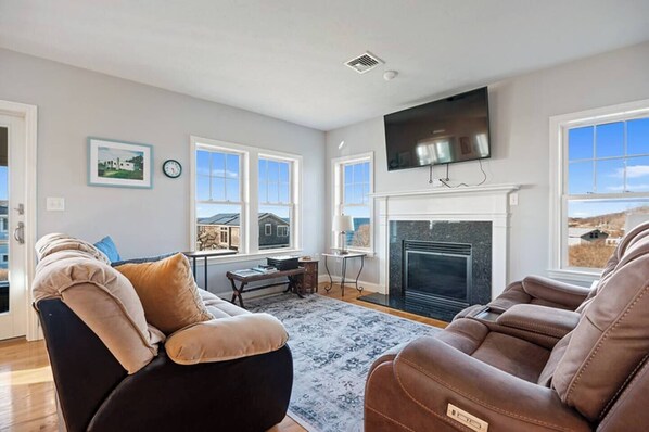 Cozy living room with a TV, fireplace, and ocean views!