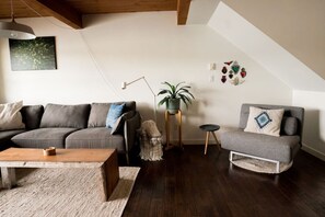 Living room with sectional and chair that folds out into a single bed.