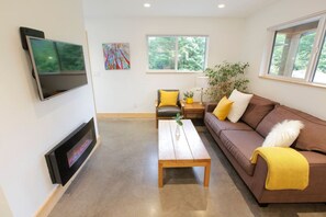 Living room space with TV and electric fireplace.