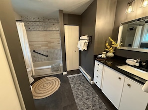 Large bathroom with laundry, tub/shower combo and lots of storage.