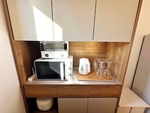 There is an oven, a range, a pot and a rice cooker.