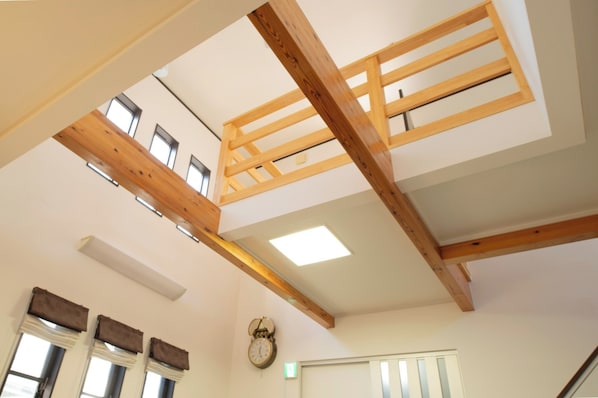 The living room has an open ceiling. The ceiling light is recessed and the door has a vertical slit. Relax and unwind after your trip in this relaxing space!