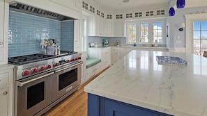 Well-equipped kitchen with quartz counter tops and Wolf range