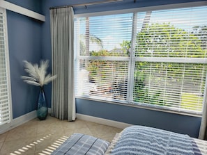 Back guest bedroom queen bed overlooking pool and canal