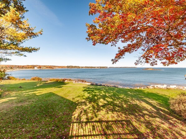 Large front lawn leading to the water