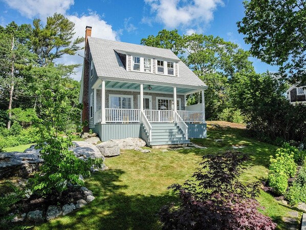 Ocean side of cottage with a small sloped yard area