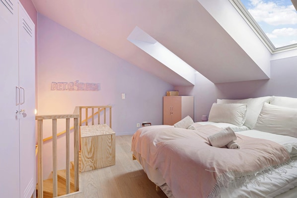 A cozy, light-filled bedroom with a soft lavender hue.