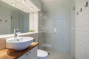 Well-lit and spacious bathroom with a glass shower enclosure.