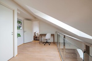A bright, airy hallway leads to a cozy workspace, perfect for remote work or quiet study time.