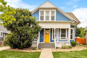 Brighten up your day with this charming house featuring a cheerful yellow door!