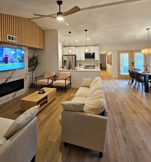 Living room featuring custom slat and marble fireplace and accent wall, smart TV