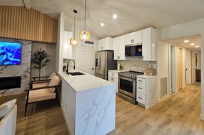 Kitchen with waterfall quartz countertop and stainless steel appliances